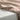 Silky fabric with a soft pinkish-beige color draped over a light gray surface.
