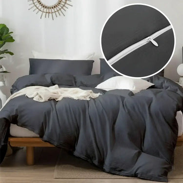 Gray bedding set on a bed with a close-up of a zipper detail.