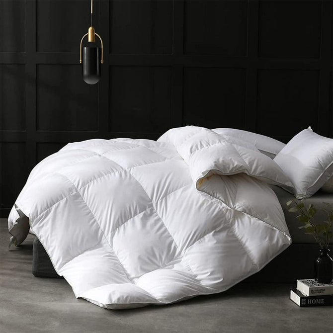 White quilted comforter on a bed in a darkly decorated room.