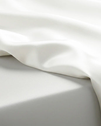 Close-up of white satin fabric with folds