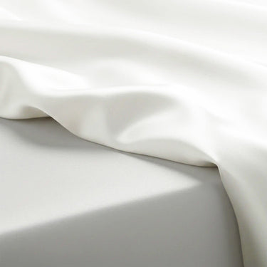 Close-up of white satin fabric with folds