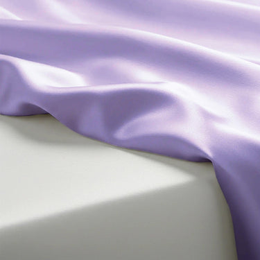 Close-up of purple satin fabric on a light gray background