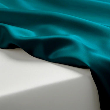 Teal fabric draped over a white surface