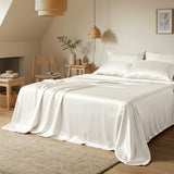 Neatly made bed with white bedding in a bedroom setting.