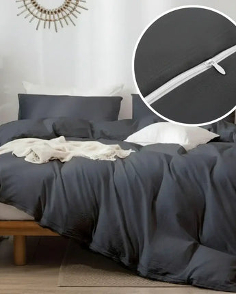 Gray bedding set on a bed with a close-up of a zipper detail.