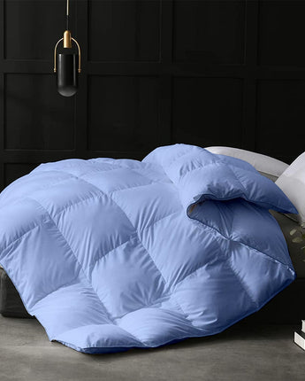 Blue quilt on a bed in a darkly decorated room.